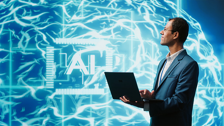 A man in a suit holds a laptop and looks thoughtfully to the side against a background of a large, digital brain graphic with neural network patterns. The word 'AI' is prominently displayed within a circuit-like frame, symbolizing artificial intelligence and the fusion of human and machine intelligence.